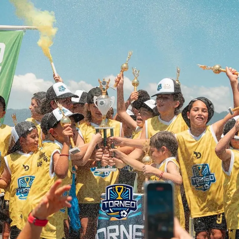 Chicos del Torneo Formativo Tucumán festejando con sus copas y camisetas amarillas